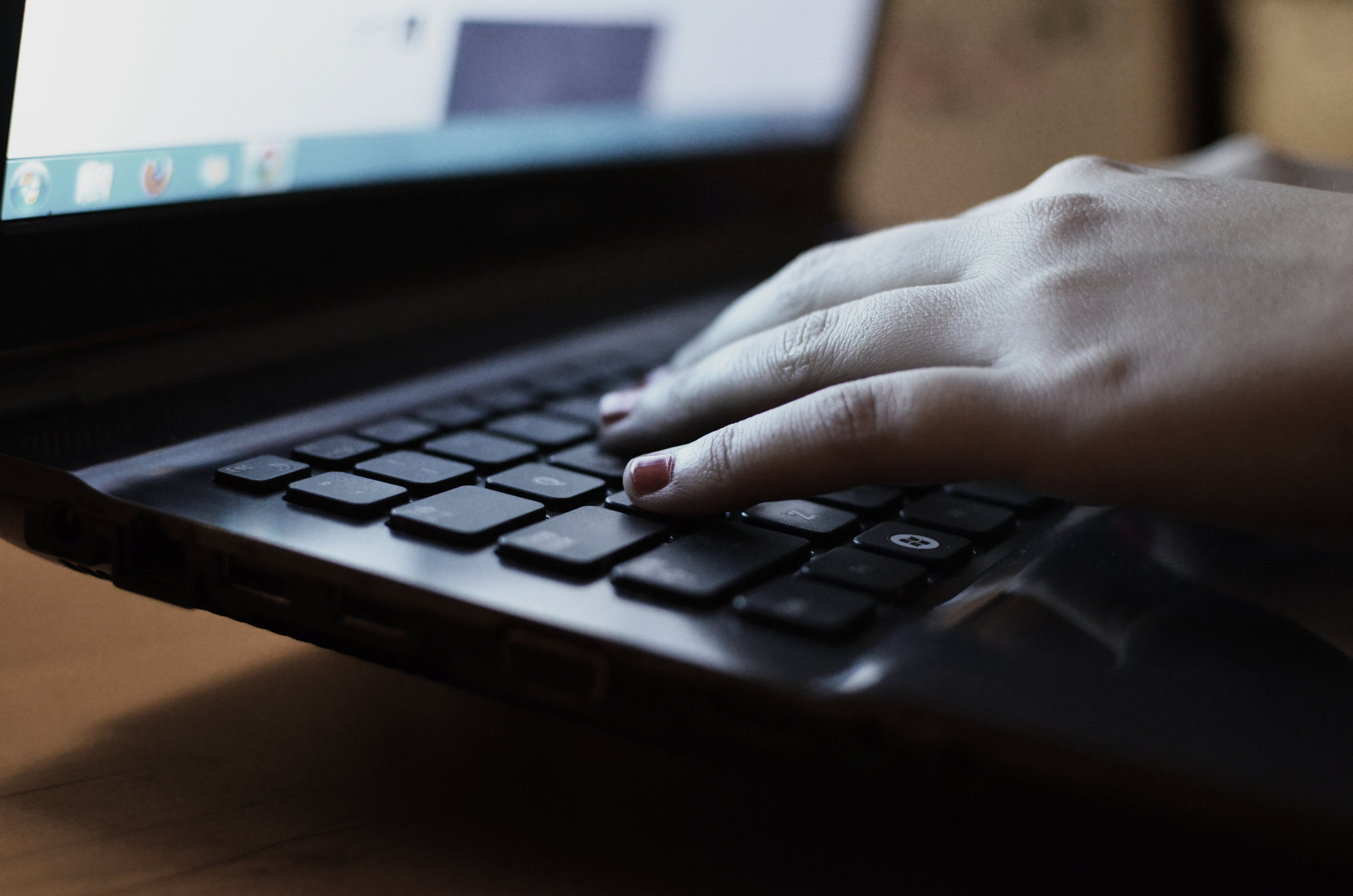 The hand types on the laptop with dark lighting to denote the use of a VPN 